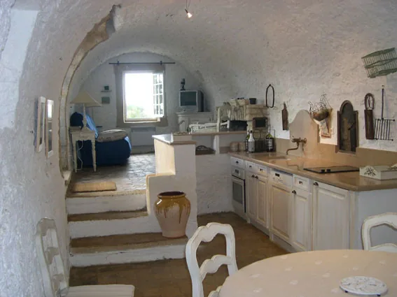 Séjour et cuisine équipée sous les voûtes blanchies du moulin